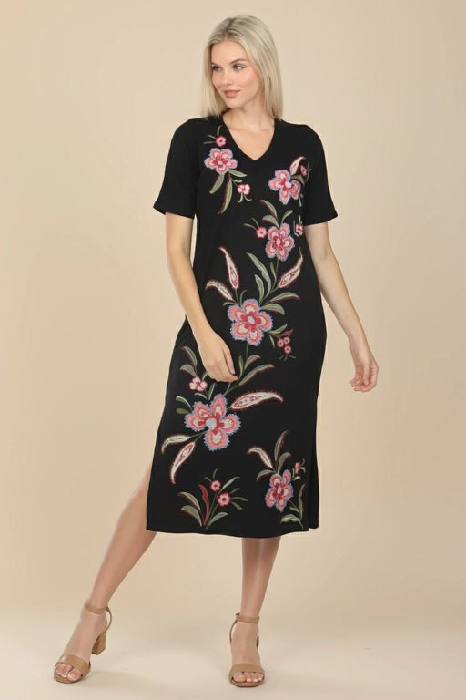 Woman wearing a black floral embroidered midi t-shirt dress with v-neck and side slit from Johnny Was