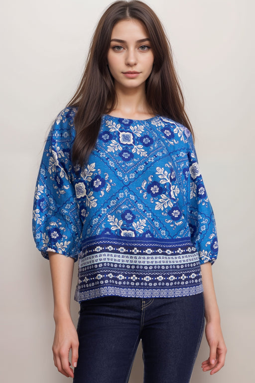Woman wearing a blue linen blouse with tile-like pattern and fair isle hem