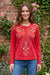 Woman wearing a red embroidered long-sleeve top with henley neckline from Johnny Was