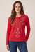 Woman wearing a red embroidered long-sleeve top with henley neckline from Johnny Was