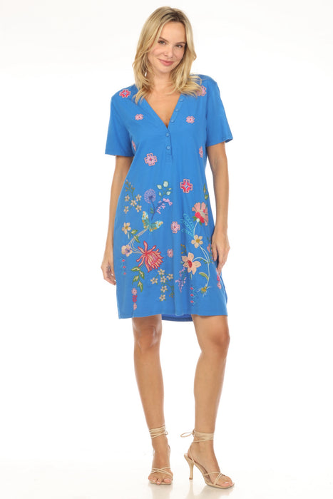 Woman wearing a blue floral embroidered dress with v-neck and buttons from Johnny Was