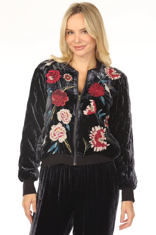 Woman wearing a dark blue velvet bomber jacket with floral embroidery and zip front from Johnny Was