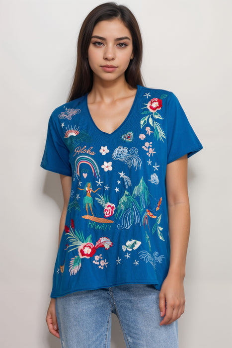 Woman wearing a blue t-shirt with colorful embroideries at the front from Johnny Was