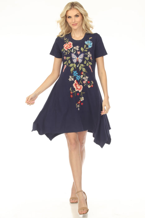 Woman wearing a blue floral embroidered cotton dress with handkerchief hem from Johnny Was