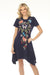 Woman wearing a blue floral embroidered cotton dress with handkerchief hem from Johnny Was
