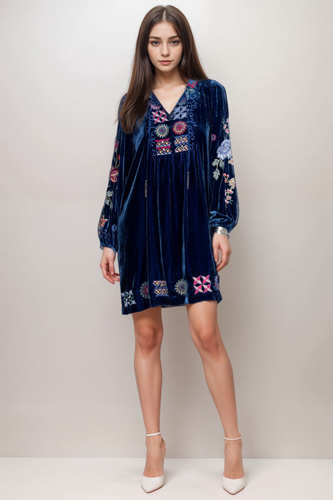 Woman wearing a navy velvet shift dress with colorful embroidery and long sleeves from Johnny Was