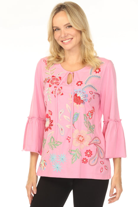 Woman wearing a pink embroidered blouse with floral patterns and 3/4 sleeves from Johnny Was