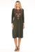 Woman wearing a green dress with intricate embroidery and boat neck from Johnny Was