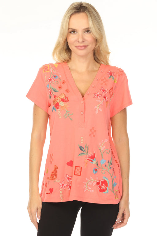 Woman wearing a coral pink tee with floral embroidery and buttoned v-neck from Johnny Was