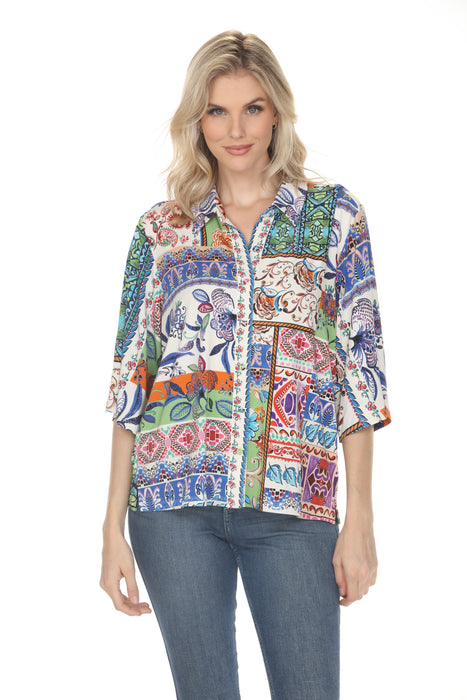 A woman wearing a colorful bohemian-style printed shirt and blue jeans, photographed against a solid white background.