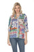 A woman wearing a colorful bohemian-style printed shirt and blue jeans, photographed against a solid white background.