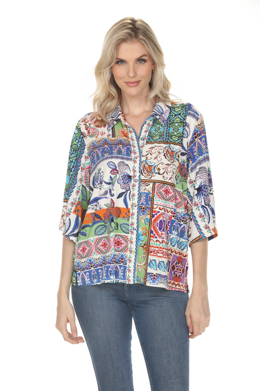 A woman wearing a colorful bohemian-style printed shirt and blue jeans, photographed against a solid white background.