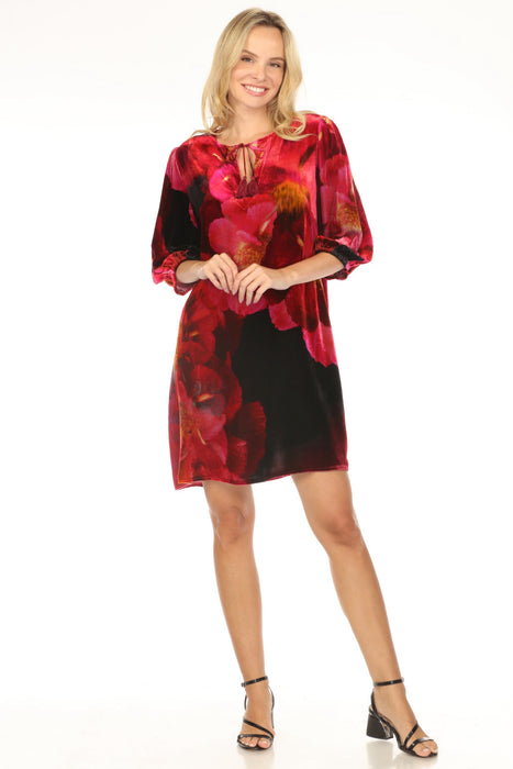 Woman wearing a velvet mini shift dress with floral pattern and tassel v-neck from Johnny Was