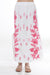 Woman wearing a white floral embroidered maxi skirt from Johnny Was