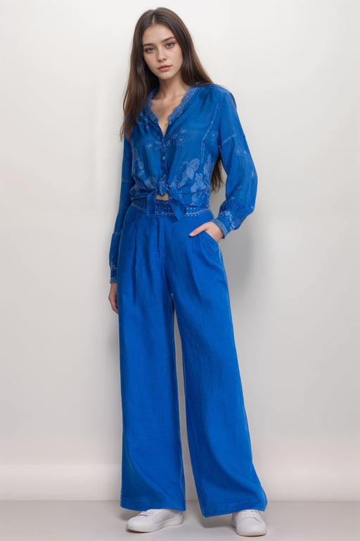 Woman wearing a blue wide leg pant with front pleat and front pockets from Johnny Was