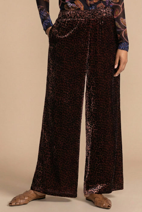 Woman wearing brown velvet wide leg pants with leopard pattern and side pockets from Johnny Was