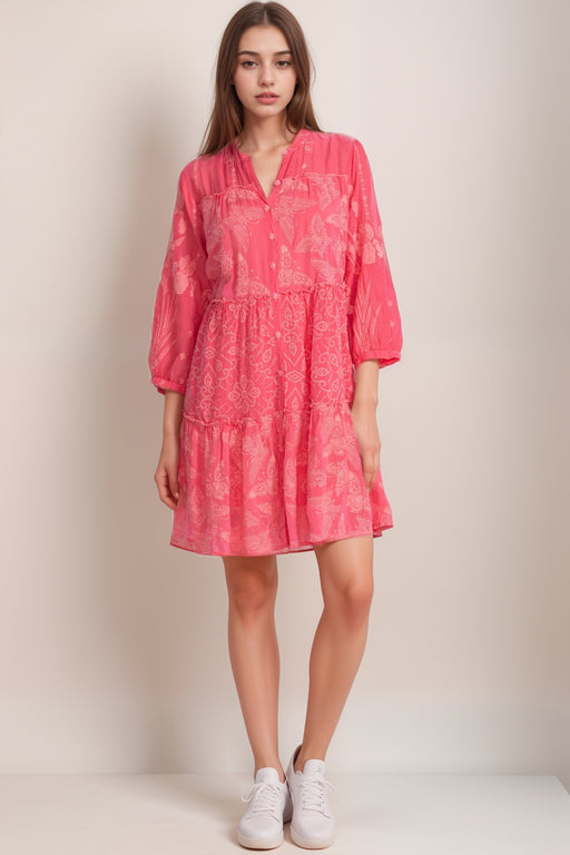 Woman wearing a pink dress with tonal embroideries and 3/4 puff sleeves