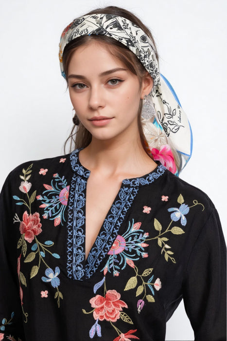 Woman wearing a white, cotton, floral head scarf from Johnny Was