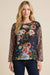 Woman wearing a floral top with leopard print sleeves and boat neck from Johnny Was