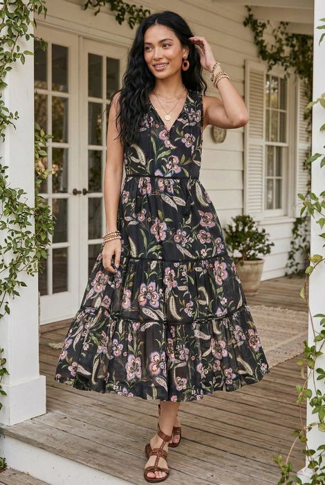 Woman wearing a black floral printed tier midi dress from Johnny Was