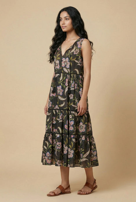 Woman wearing a black floral printed tier midi dress from Johnny Was