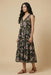 Woman wearing a black floral printed tier midi dress from Johnny Was