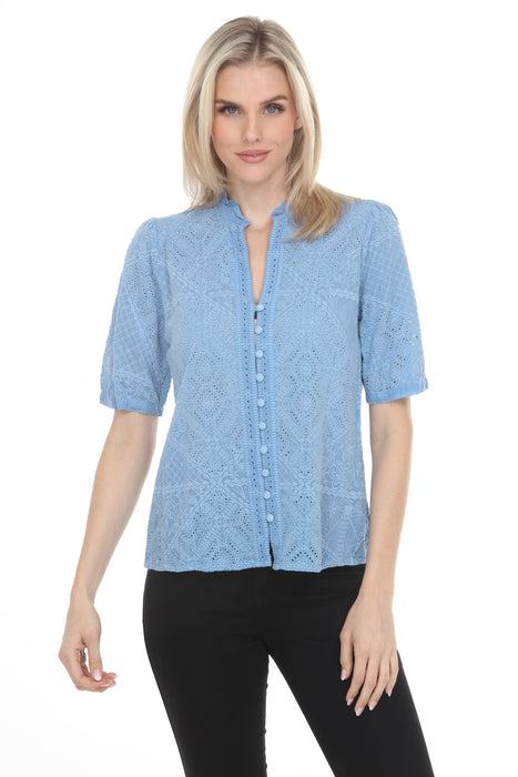 Woman wearing a light blue button front top with intricate tonal embroidery and short sleeves from Johnny Was