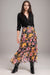 Woman wearing a colorful floral silk maxi skirt with tiered ruffles