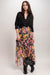 Woman wearing a colorful floral silk maxi skirt with tiered ruffles