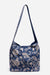 A navy blue shoulder bag with a white floral and botanical pattern, featuring a single shoulder strap and a structured, soft slouchy silhouette, shown against a plain light gray background.