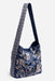A navy blue fabric shoulder bag with a white floral and bird pattern, featuring a wide shoulder strap with a white geometric border, set against a light gray background.