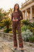 Woman wearing leopard printed henley top with colorful florals and long sleeves from Johnny Was