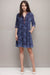 Woman wearing a blue butterfly embroidered dress with half sleeves and side pockets from Johnny Was