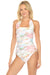 Woman wearing a marble patterned one piece swimsuit with ruching and halter straps from Johnny Was