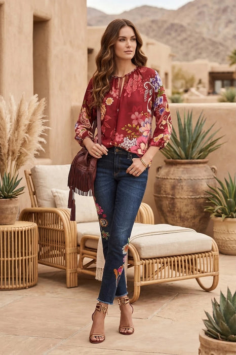 Woman wearing a red floral printed blouse with 3/4 puff sleeves from Johnny Was