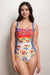 Woman wearing a colorful floral one piece swimsuit with ruching at the front from Johnny Was