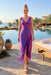 Woman wearing a purple midi wrap dress with pink seashell print and tie waist from Johnny Was