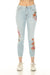 Woman wearing a light blue skinny denim jean with floral embroidery and crop frayed hem from Johnny Was