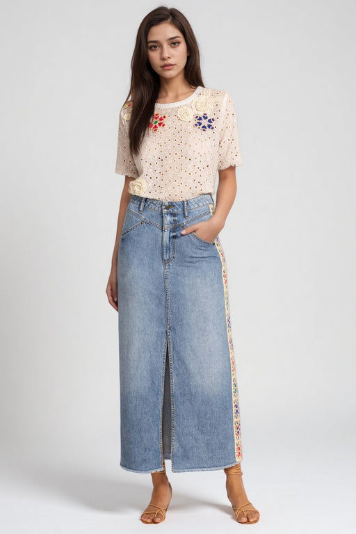 Woman wearing a medium wash denim skirt with front slit and crochet side seams from Johnny Was