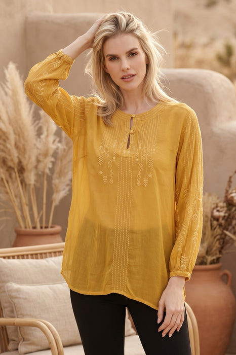Woman wearing a yellow tunic top with tonal embroidery and bishop sleeves from Johnny Was