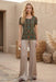 Woman wearing green short sleeve mesh tee with colorful floral and geometric patterns from Johnny Was