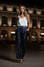 Woman wearing navy sequined wide leg pants with striped waistband and side pockets from Johnny Was