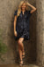 Woman wearing a navy sequin mini dress with v-neck and short sleeves from Johnny Was