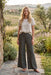 Woman wearing a green wide leg pants with tonal embroideries from Johnny Was