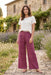 Woman wearing a purple wide leg pants with tonal embroideries from Johnny Was