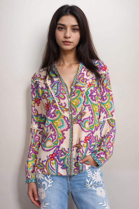Woman wearing a colorful paisley patterned silk shirt with long sleeves and v-neck from Johnny Was