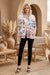 Woman wearing a white open front jacket with colorful embroideries and side pockets from Johnny Was