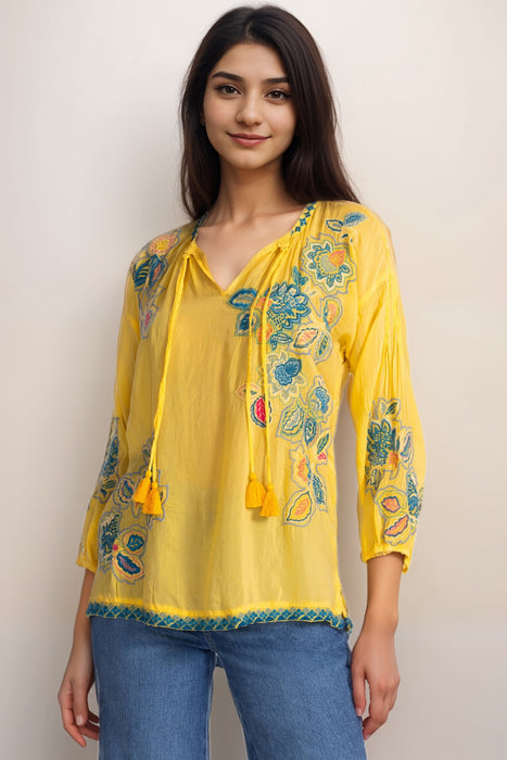 Woman wearing a yellow floral embroidered top v-neck tassel tie