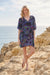 Woman wearing vibrant paisley print, relaxed bohemian silhouette, lightweight fabric, and flattering mini length for a chic everyday or resort look.
