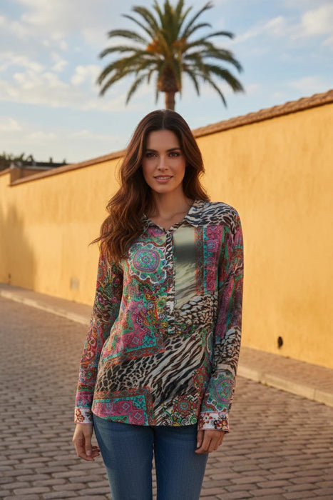 Woman wearing a colorful patterned long sleeve top with paisley and animal prints from Johnny Was